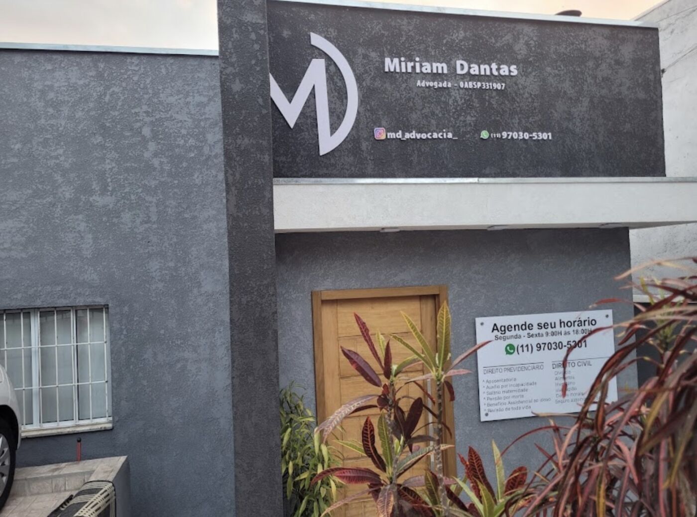 Fachada do escritório MD Advocacia, com a placa Miriam Dantas e a porta de madeira